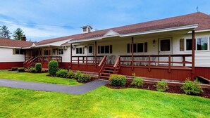 Une rangée de bâtiments d’un seul étage, typiques des motels, avec une véranda couverte et un petit jardin devant.