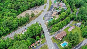 Vista aérea de una zona residencial con varias calles, casas y una piscina.