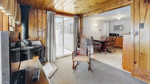 Un interior de madera con chimenea, comedor y cocina.