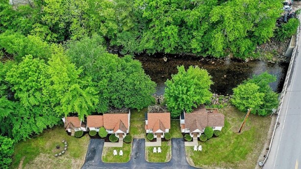 An aerial view of a residential area with houses, a road, and a river. - Eclectic Studio Cabin w/ Kitchenette, Free WiFi, Riverfront Location & More (Lincoln)