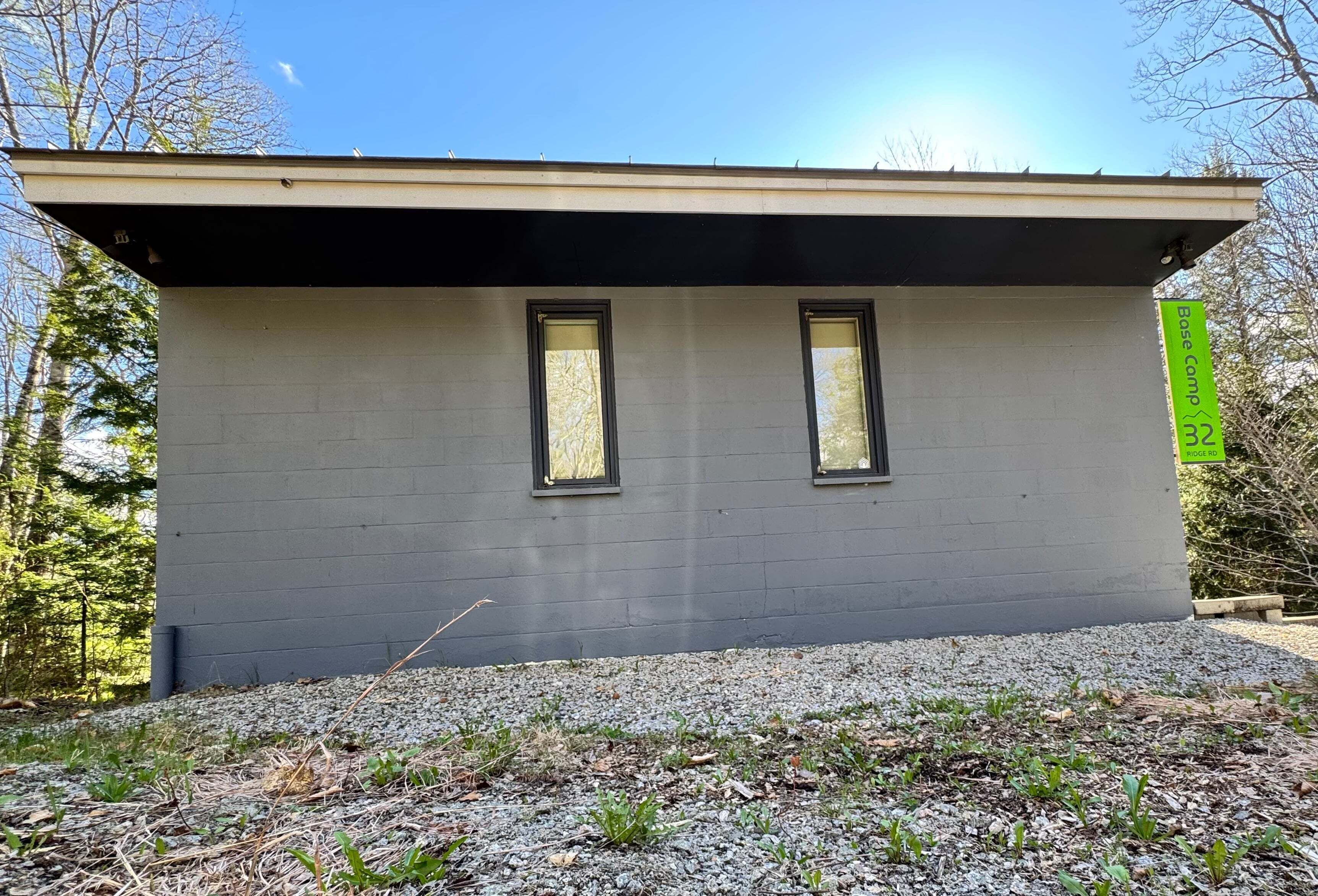 A small, single-story building with a flat roof and two windows.