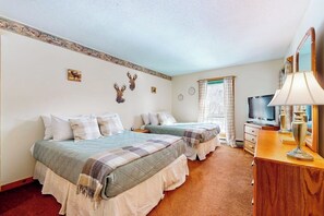 A room with two beds, a TV, a lamp, and a mirror. - Mountain-view, riverfront retreat with seasonal AC, pool, tennis, washer/dryer (Lincoln)