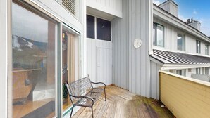 Un balcon avec un banc, une horloge et une vue sur la mer.