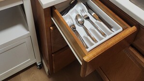 Eine Küche mit Mikrowelle, Kaffeemaschine und einer Schublade mit Besteck.