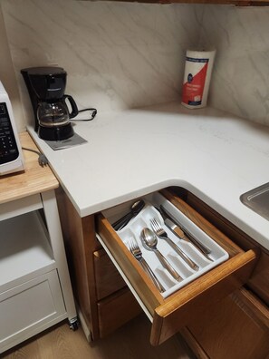A kitchen with a microwave, coffee maker, and a drawer with utensils. - Cozy 1-bedroom apartment in Rittenhouse Square, Philadelphia (Philadelphia)
