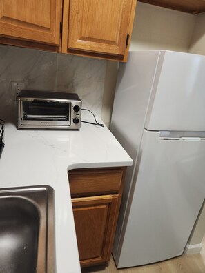 A kitchen with a toaster oven, a sink, and a refrigerator. - Cozy 1-bedroom apartment in Rittenhouse Square, Philadelphia (Philadelphia)
