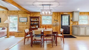 Interior de madera con comedor, cocina y una puerta que indica 'Pine Tree Inn'.