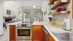 Una cucina con isola centrale, mobili in legno e forno integrato.
