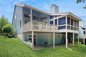 Ein zweigeschossiges Haus mit Balkon, Schornstein und überdachter Terrasse.