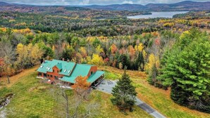 A house with a green roof surrounded by autumn foliage.
