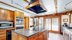 A spacious kitchen with wooden cabinets, stainless steel appliances, and a large island.