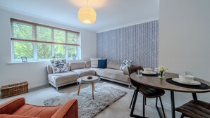 Una sala de estar moderna con un sofá, una mesa de comedor y una pared con estampado.