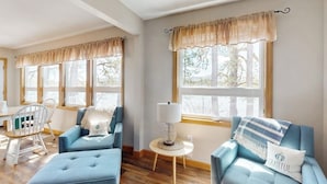 A room with two blue sofas, a small round table with a lamp, and a chair. - Lakefront home with private beach, access to dock/fishing/kayaks/boat slip (Ossipee)