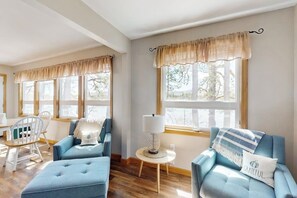 A room with two blue sofas, a small round table with a lamp, and a chair. - Lakefront home with private beach, access to dock/fishing/kayaks/boat slip (Ossipee)