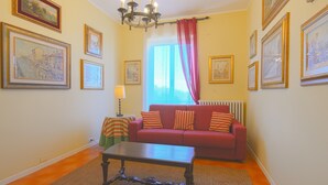 Ein Wohnzimmer mit einem roten Sofa, einem Couchtisch und einer Chandelier.