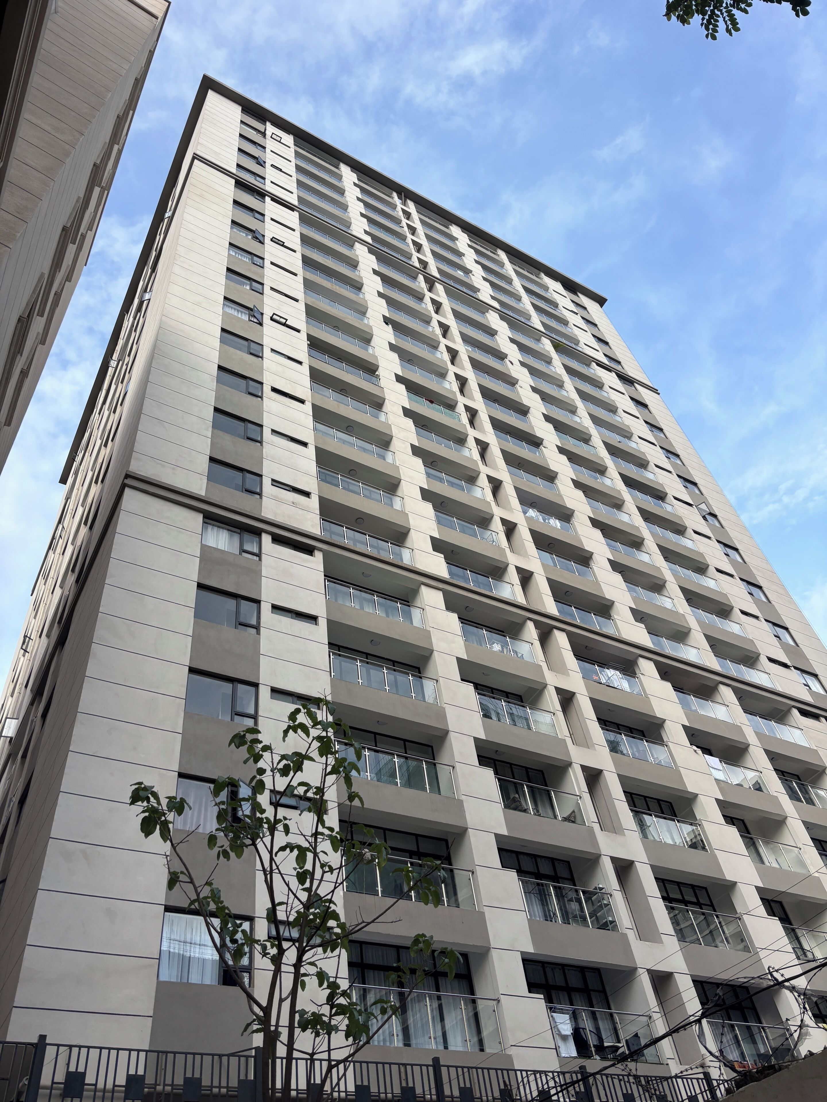 A high-rise building with multiple balconies and large windows.