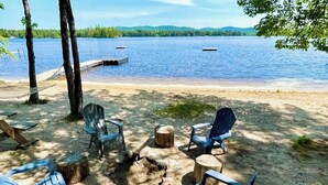A lakeside setting with outdoor seating and a fire pit.