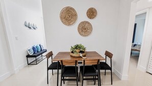Ein Essbereich mit einem Holztisch, vier Stühlen und dekorativer Wandgestaltung.
