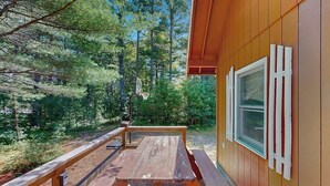 Una cabaña de madera con una mesa de picnic y un aro de baloncesto.
