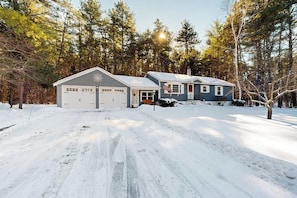 A two-story house with a garage, a covered porch, and a flag. - Mountain home near shops, hiking, skiing, restaurants & brewery (North Conway)