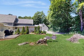 A residential property with a well-maintained lawn, a barbecue area, and a garage. - Intown home w/ views, private deck & firepit; close to Mt. Cranmore (North Conway)