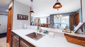 A modern kitchen with a large island, pendant lighting, and a view to the living area. - Renovated Ski-in/Ski-Out Condo w/ Shared Pools, Hot Tub, Sauna & Great Location (Dover)