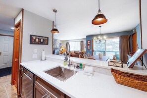 A modern kitchen with a large island, pendant lighting, and a view to the living area. - Renovated Ski-in/Ski-Out Condo w/ Shared Pools, Hot Tub, Sauna & Great Location (Dover)
