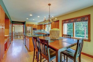 Una cocina amplia con armarios de madera, una isla grande y un comedor con sillas.