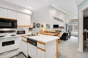 A modern kitchen with white cabinetry, a microwave, a toaster, and a dishwasher.