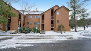 A multi-story building with a symmetrical facade, balconies, and a central entrance with steps. - Slopeside condo with nearby skiing, balcony, fireplace, & washer/dryer (Dover)