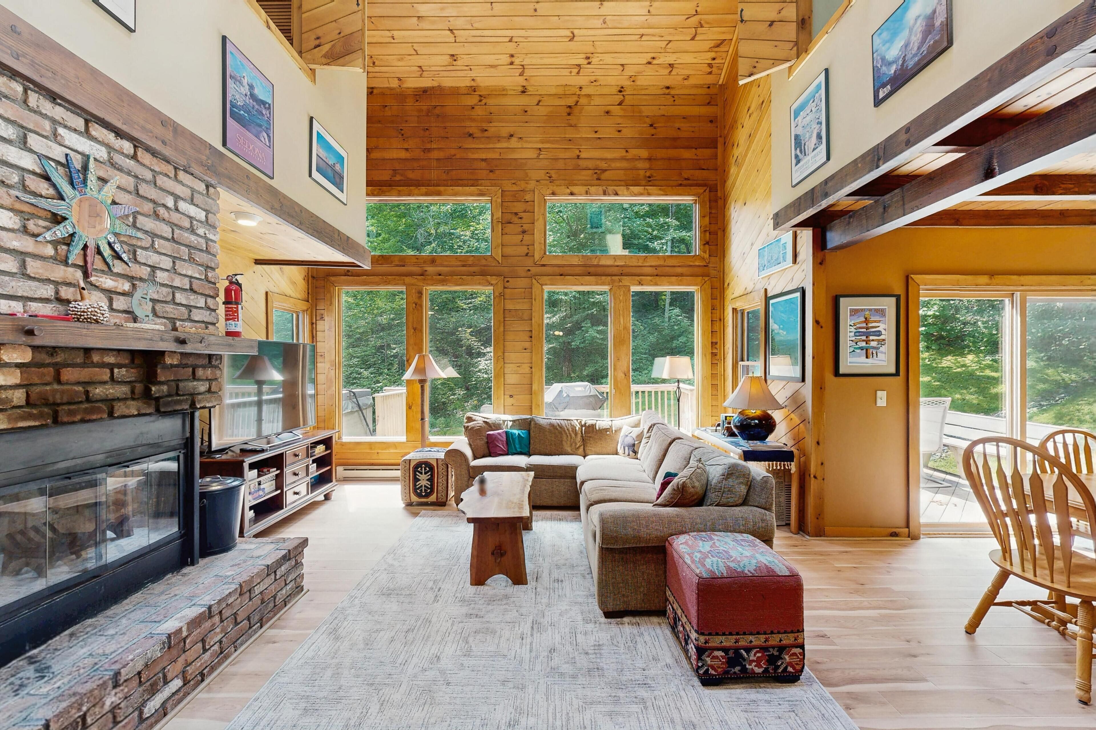A spacious living room with a fireplace, large windows, and a cozy seating area.