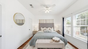 A bedroom with a bed, a round mirror, a ceiling fan, and a window with blinds. - Newly Furnished Cozy 2B~Mins to Medical center&NRG~Near Rice U~ Downtown Houston (Houston)