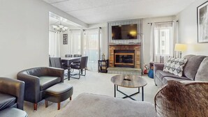 Una sala moderna con chimenea, televisor de pantalla plana y comedor.