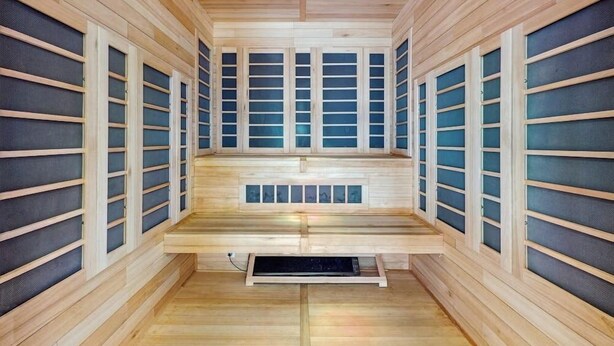 Una sauna de madera con bancos y paneles de vidrio esmerilado.