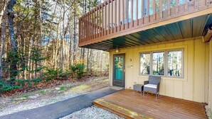 A cabin with a deck, a door, and a window.