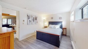 A bedroom with a bed, a desk, and a lamp.