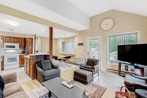 A spacious living area with a kitchen, dining area, and a TV. - All-season landing pad with resort amenities, mtn views, & W/D - dog-friendly (Waterville Valley)