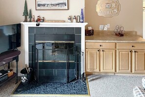 Ein Wohnzimmer mit Kamin, Fernseher und Küchenzeile mit Schränken.