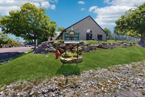 A building with a sign indicating it is a pool and office, surrounded by a well-maintained lawn and rocks. - Ski-In/Ski-Out Condo w/ Pool & Seasonal Hot Tubs - Golf & Tennis Nearby (Ludlow)