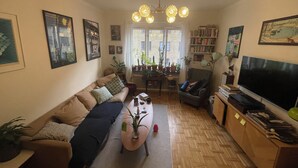 A living room with a sofa, a coffee table, a TV, and a bookshelf. - Cozy flat in a quiet, leafy neighborhood in central Malmö (Malmö)