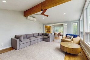 A modern living room with a sectional sofa, a round coffee table, and a ceiling fan. - Beautiful house w/ mountain views, fireplace, balcony, bbq, gameroom, w/d, a/c (Dover)