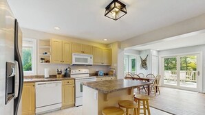 A kitchen with a central island, wooden cabinets, a microwave, and a dishwasher. - Beautiful house w/ mountain views, fireplace, balcony, bbq, gameroom, w/d, a/c (Dover)