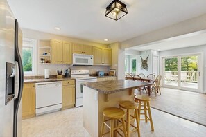 A kitchen with a central island, wooden cabinets, a microwave, and a dishwasher. - Beautiful house w/ mountain views, fireplace, balcony, bbq, gameroom, w/d, a/c (Dover)