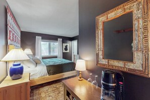 A hotel room with a bed, bedside lamps, a coffee maker, a mirror, and a window with curtains. - Studio w/ mountain view, shared pool, hot tub, sauna, tennis courts & shuttle (Dover)