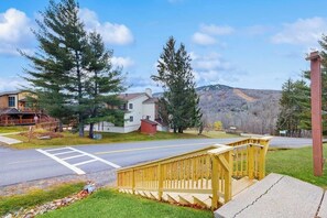 A residential street with houses, a wooden deck, and a clear sky. - Studio w/ mountain view, shared pool, hot tub, sauna, tennis courts & shuttle (Dover)