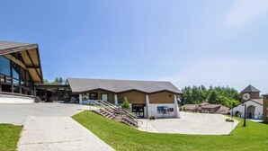 A modern building with a large glass facade, a covered entrance, and a clock tower. - Ski-in/out mountainside condo close to everything with full kitchen - tranquil (Ludlow)