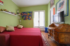 A room with a bed, a TV, a dresser, and a painting on the wall. - 100. Studied, Villa On The Lake (Piemonte)