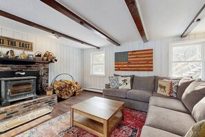 A cozy living room with a fireplace, a sofa, a coffee table, and a rug. - White Mountain home w/ yard near skiing, hiking & tubing (Campton)