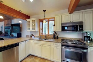 A kitchen with white cabinets, a stainless steel stove, a microwave, and a dishwasher. - Bright, Open Home with Wraparound Deck & Mountain Views - 2 Miles to Skiing (Ludlow)