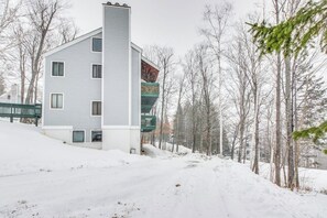 A multi-story building with a prominent vertical structure, surrounded by snow-covered ground and leafless trees.